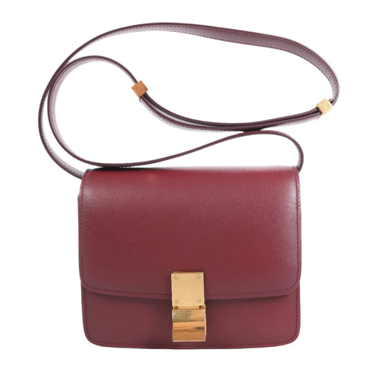 Red handbag with a gold clasp on a white background
