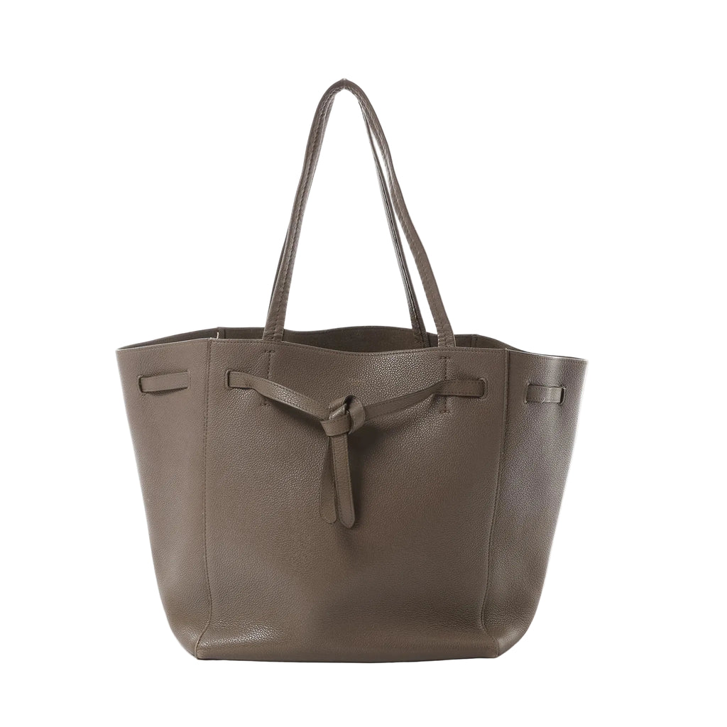 Céline Cabas Phantom Small taupe grained leather tote with shoulder straps and front tie detail, front view on white background.
