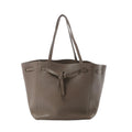 Céline Cabas Phantom Small taupe grained leather tote with shoulder straps and front tie detail, front view on white background.