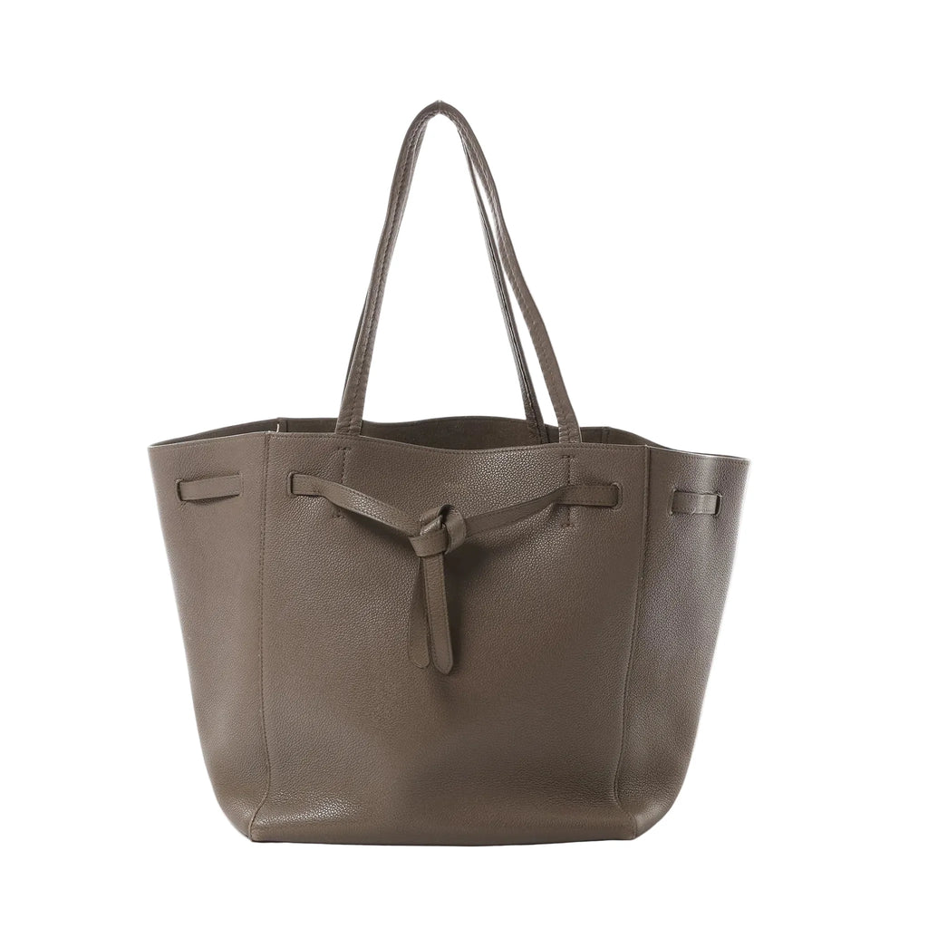 Céline Cabas Phantom Small taupe grained leather tote with shoulder straps and front tie detail, front view on white background.