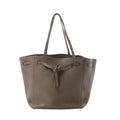 Céline Cabas Phantom Small taupe grained leather tote with shoulder straps and front tie detail, front view on white background.