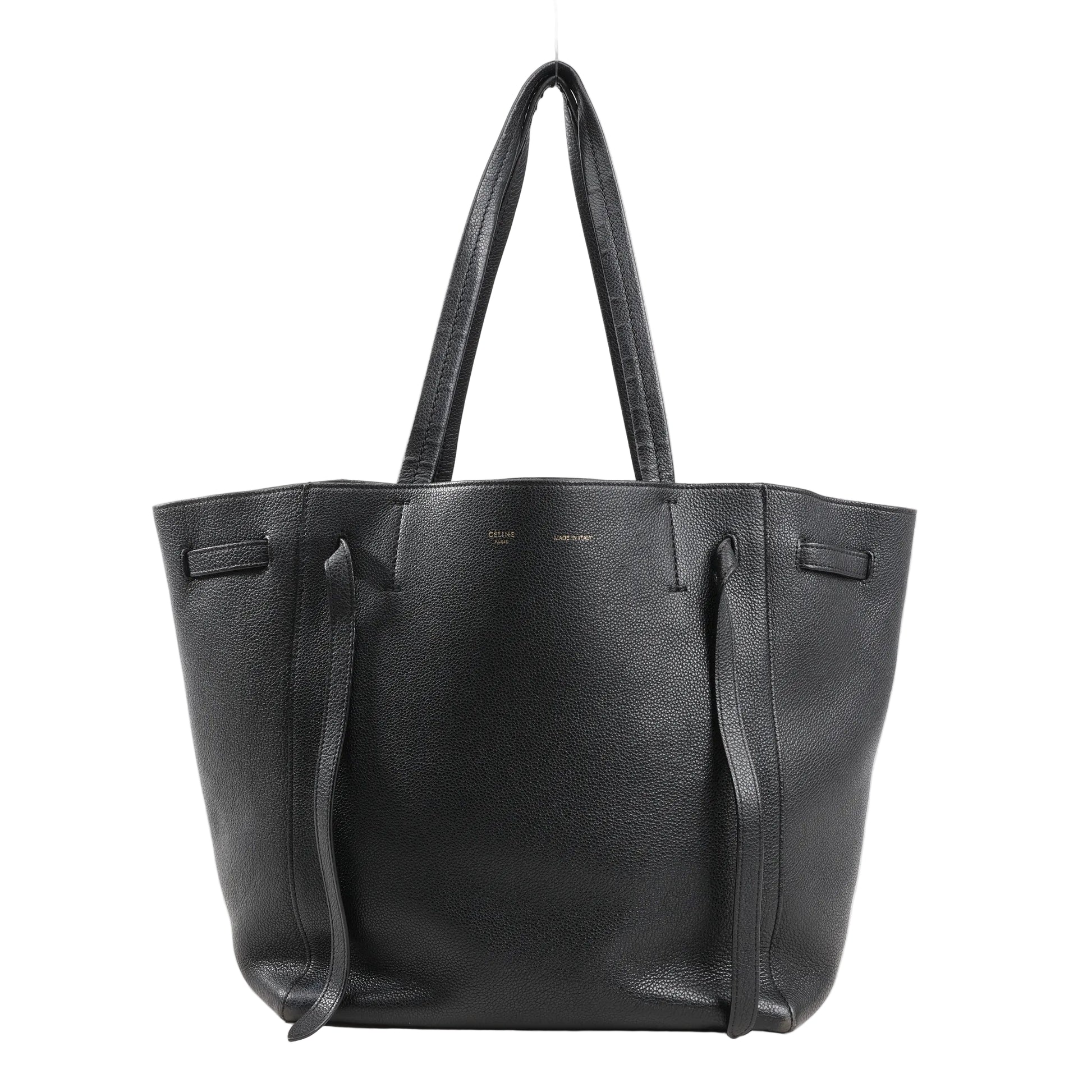 Celine Cabas Phantom Small Shoulder Bag in black grained leather with long top handles, side tie details, and a structured open-top silhouette on a white background.