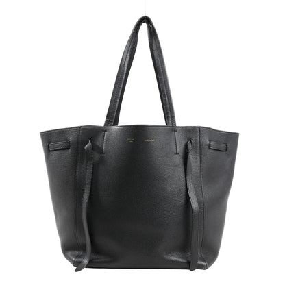 Celine Cabas Phantom Small Shoulder Bag in black grained leather with long top handles, side tie details, and a structured open-top silhouette on a white background.