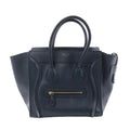 Front view of a navy blue Celine Luggage Micro leather handbag with winged sides, rolled top handles and a gold-tone front zip pocket.
