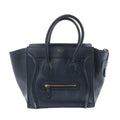 Front view of a navy blue Celine Luggage Micro leather handbag with winged sides, rolled top handles and a gold-tone front zip pocket.