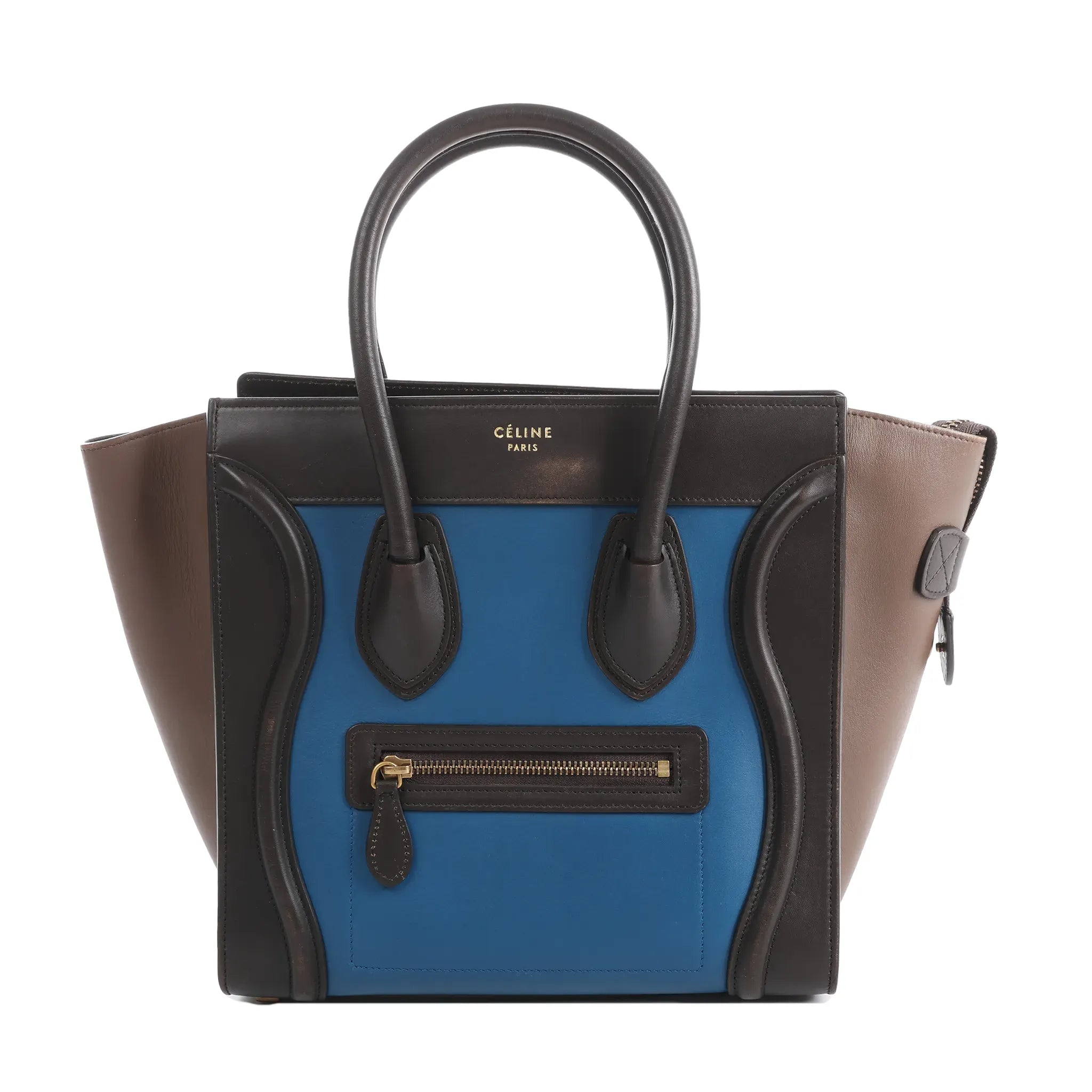 Celine Luggage Micro handbag in blue leather with black trim, taupe side panels, top handles, and front zip pocket on white background