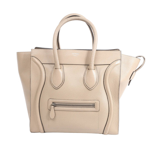 Celine Luggage Mini Leather Handbag in beige grained leather with dual rolled handles, winged sides, front zip pocket, and structured silhouette, shown standing upright against a white background.