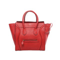 Red Celine Luggage Mini leather handbag with two top handles, signature curved front panels, front zip pocket with leather pull, and winged sides, shown on a white background.