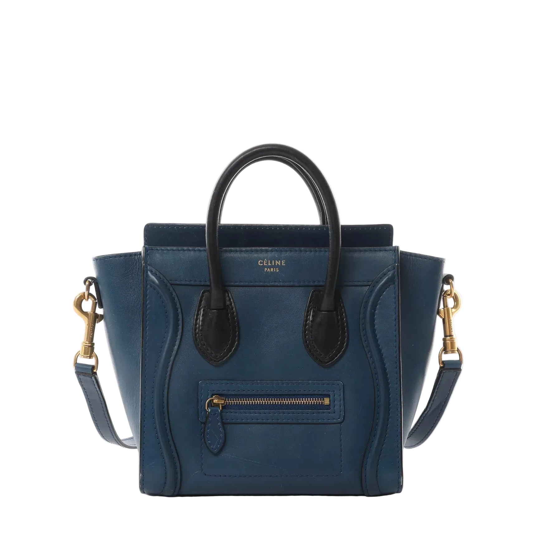 Navy blue leather Celine Nano Luggage handbag with black top handles, detachable shoulder strap, gold-tone hardware, and front zip pocket on a white background.