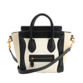 CELINE Nano Luggage 2Way handbag in black and white grained leather with top handles, front zip pocket, and detachable shoulder strap.