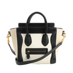CELINE Nano Luggage 2Way handbag in black and white grained leather with top handles, front zip pocket, and detachable shoulder strap.