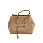 Beige Celine Luggage Phantom leather handbag with rounded top handles, red edge accents, sculpted piping and front zip pocket with braided pull.