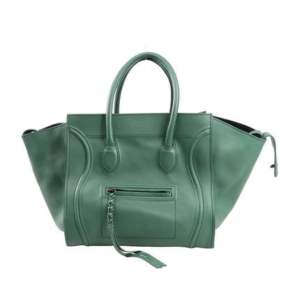 CELINE Luggage Phantom Small handbag in green leather with structured silhouette, braided front zipper pull, and dual top handles against a white background.