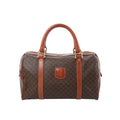 Front view of Celine Macadam Boston brown monogram PVC handbag with tan leather top handles, leather trim, zip-top closure, and front logo patch on a white background.