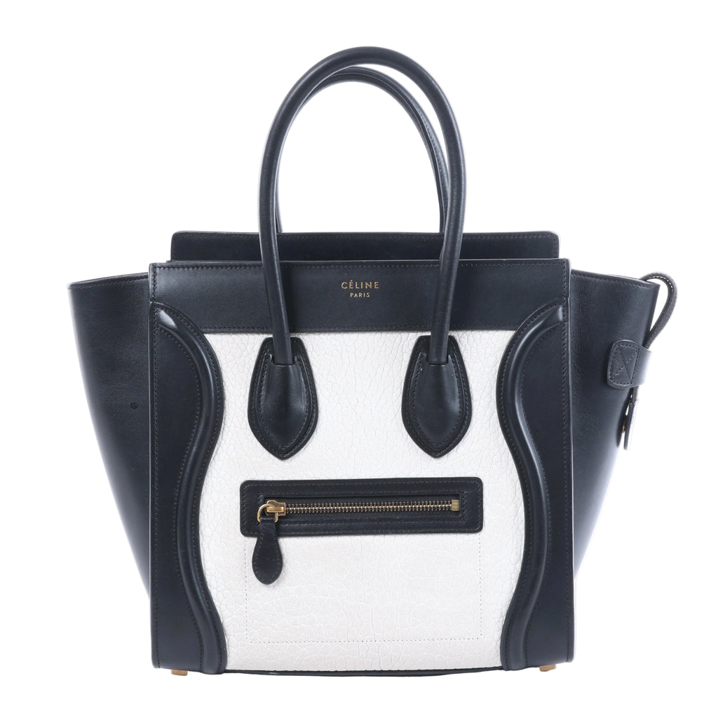 Celine Luggage Micro black and white leather handbag with top handles, winged sides and front zip pocket.