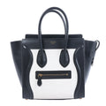 Celine Luggage Micro black and white leather handbag with top handles, winged sides and front zip pocket.