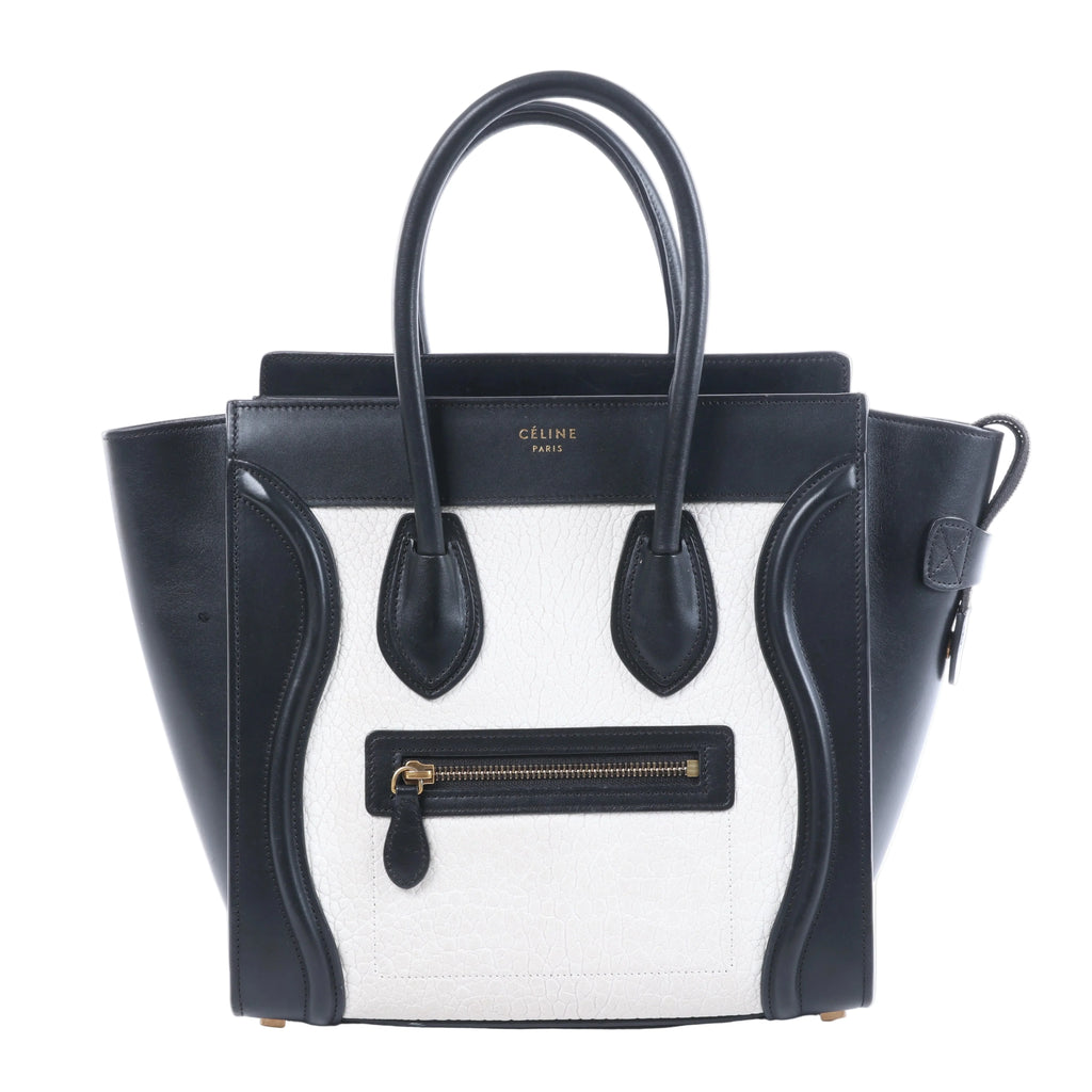 Celine Luggage Micro black and white leather handbag with top handles, winged sides and front zip pocket.