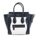Celine Luggage Micro black and white leather handbag with top handles, winged sides and front zip pocket.