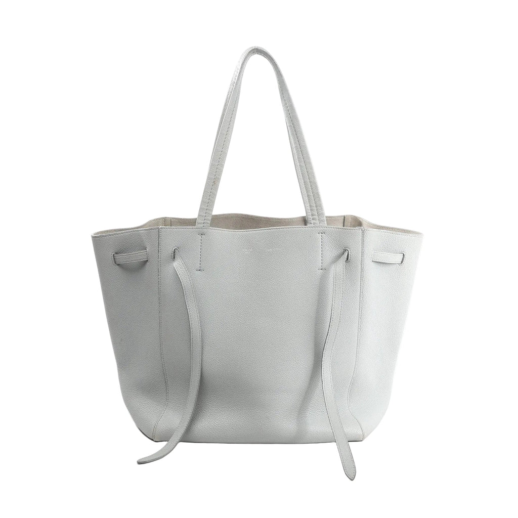 Celine Cabas Phantom Small tote in gray pebbled leather with long shoulder straps and side tie details, front view on white background.
