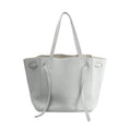 Celine Cabas Phantom Small tote in gray pebbled leather with long shoulder straps and side tie details, front view on white background.