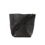 Black Celine Seau Sangle leather bucket shoulder bag with wide black web strap and small gold Celine Paris logo, shown on a white background.