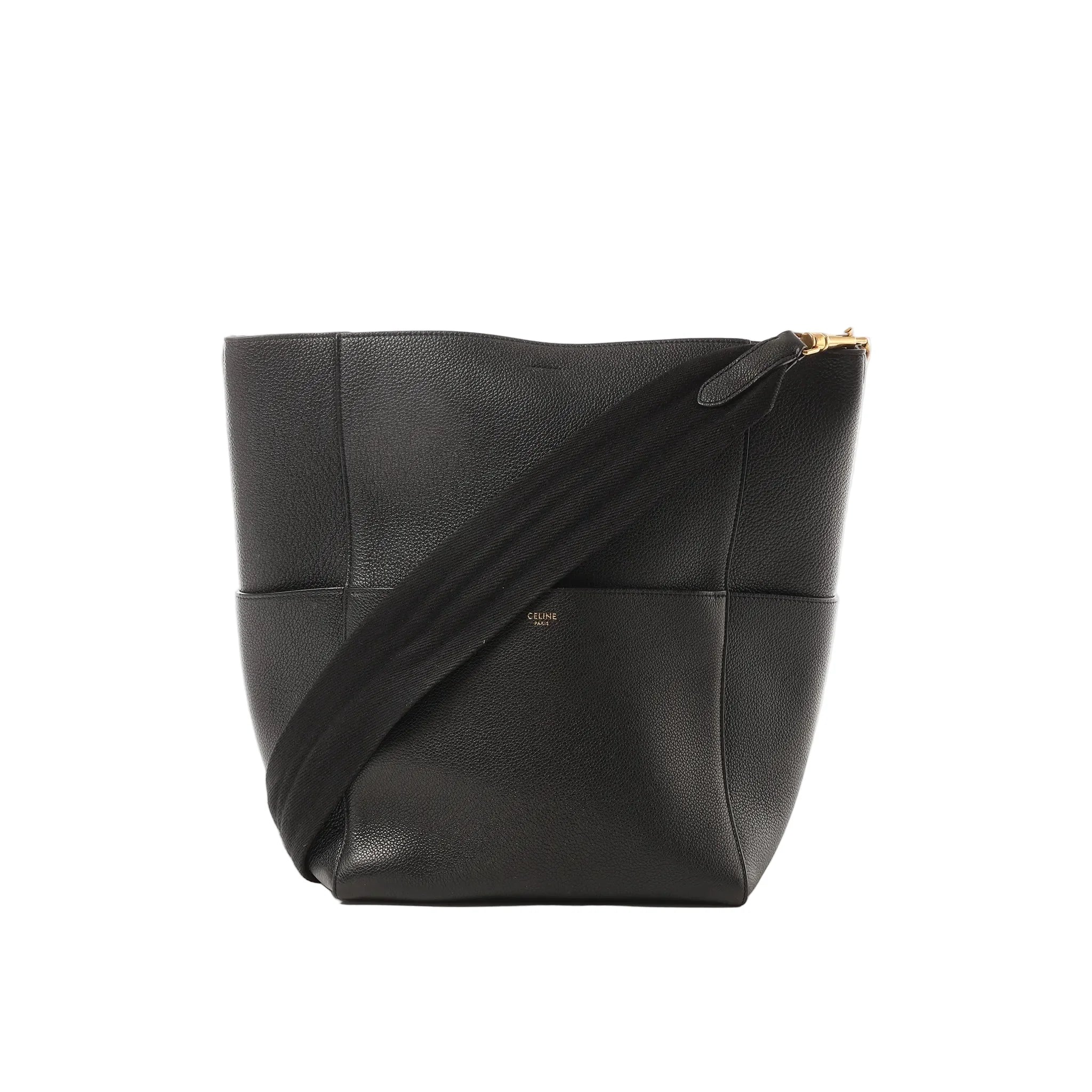 Black Celine Seau Sangle leather bucket shoulder bag with wide black web strap and small gold Celine Paris logo, shown on a white background.