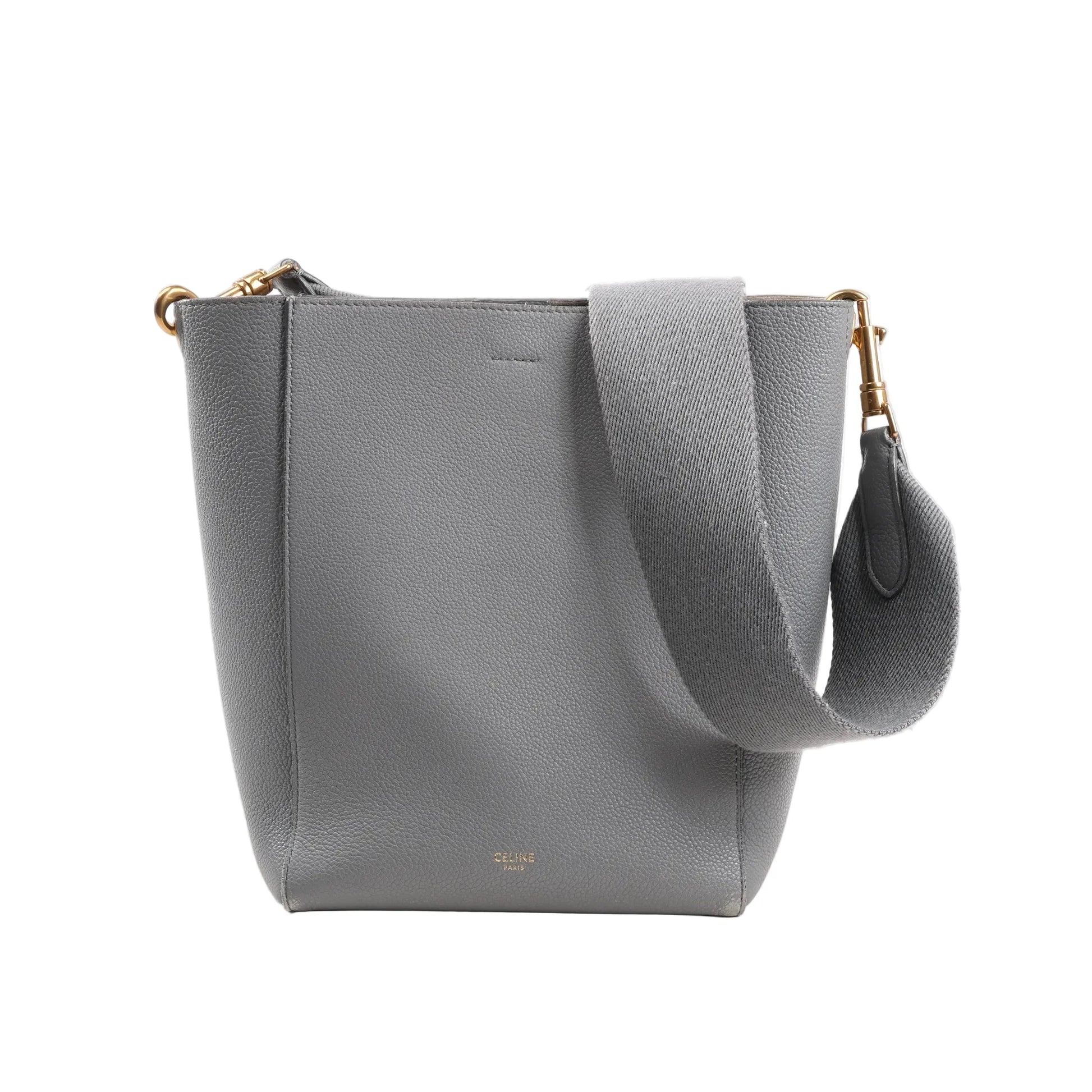 CELINE Seau Sangle Bucket Mini Shoulder Bag in gray grained leather with a wide adjustable strap, gold-tone hardware, and minimalist logo stamp at the bottom front, displayed upright on a white background.