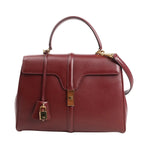 Celine Sac 16 Medium handbag in smooth burgundy leather with a structured silhouette, top handle, detachable shoulder strap, gold-tone turn-lock closure, and matching padlock charm.