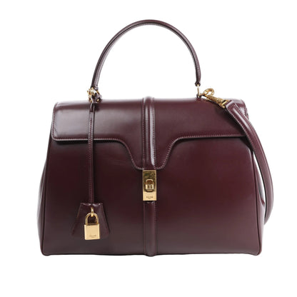 Celine Sac 16 Medium 2Way Handbag in smooth burgundy leather with gold-tone turn-lock closure, matching padlock, structured top handle, and detachable shoulder strap, displayed against a white background.