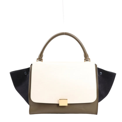 CELINE Trapeze 2Way handbag in beige leather with black suede side wings, khaki green base, top handle, and gold-tone front clasp, structured with modern elegance.