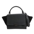 CELINE Trapeze 2Way handbag in black grained leather with suede side wings, featuring a structured flap front, top handle, detachable shoulder strap, and silver-tone hardware.