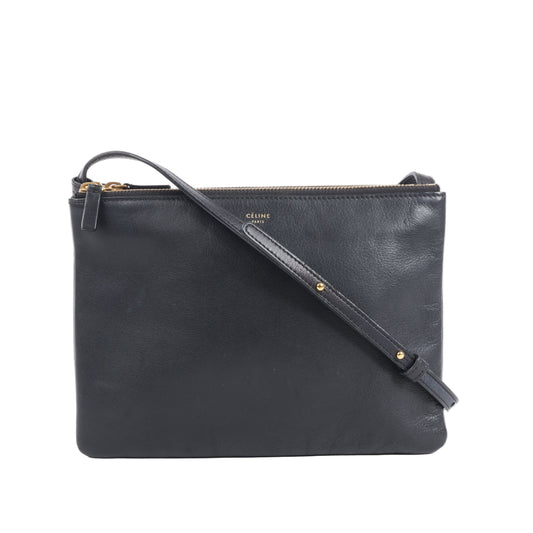 Celine Trio Large Crossbody Bag in smooth black leather with three zippered compartments, gold-tone hardware, and an adjustable shoulder strap, displayed against a white background.