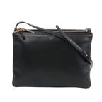 Front view of the Celine Trio Large Leather Crossbody Bag in black, showcasing smooth black calfskin leather, gold-tone zippers, an adjustable leather shoulder strap, and subtle Celine Paris branding, all set against a white background.