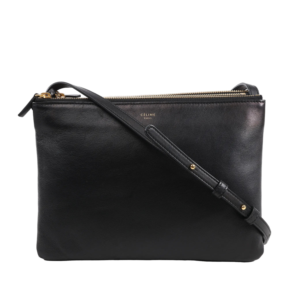 Celine Trio Large Leather Crossbody Bag in black smooth leather with gold-tone zippers, three connected zip compartments, and adjustable shoulder strap, displayed upright against a white background.