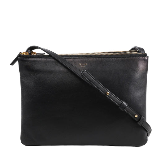 Celine Trio Large Leather Crossbody Bag in black smooth leather with gold-tone zippers, three connected zip compartments, and adjustable shoulder strap, displayed upright against a white background.