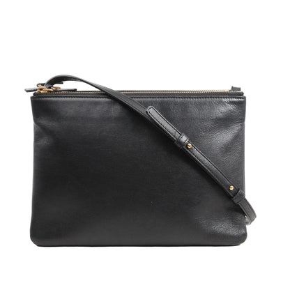 Front view of a Celine Trio Large Crossbody Bag in smooth black leather featuring a clean rectangular silhouette, adjustable leather shoulder strap with gold-tone hardware, and multiple zippered compartments.