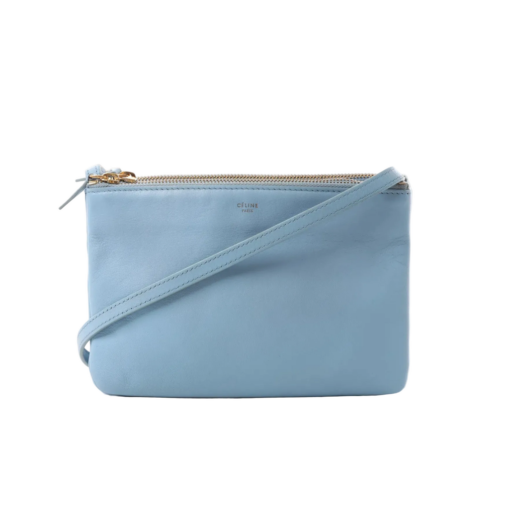 Celine Trio Small blue leather crossbody bag with zip-top closure, slim leather shoulder strap, and gold-tone zipper hardware.