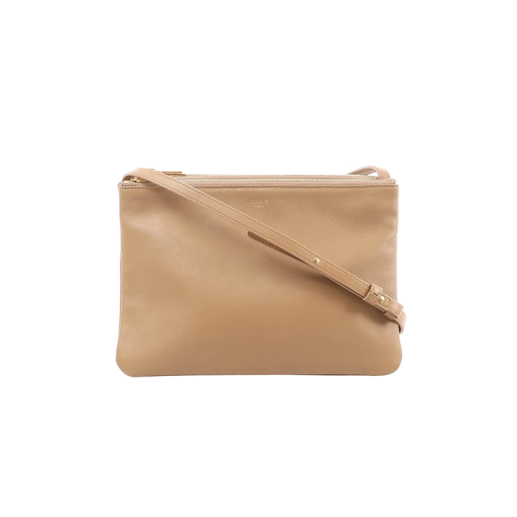 Beige Celine Trio Large leather crossbody bag with slim shoulder strap, gold-tone top zip closure, and Celine Paris logo on front.