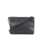 Black Celine Trio Small leather crossbody bag with zip-top closure, slim strap, and small gold logo on a white background