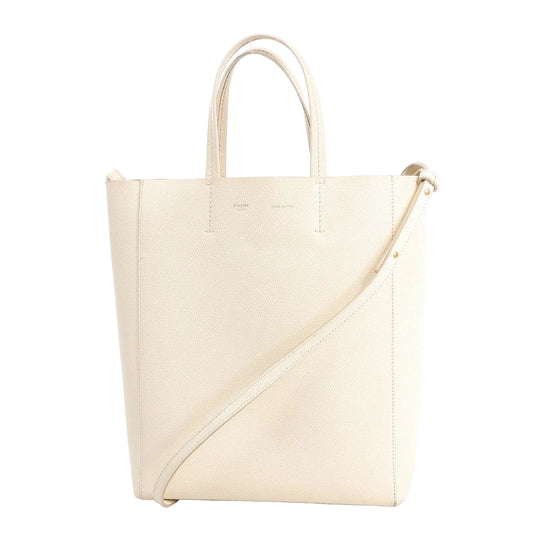 Celine Vertical Cabas Phantom Small Shoulder Bag in white grained leather featuring dual top handles, an adjustable crossbody strap, and clean minimalist design.