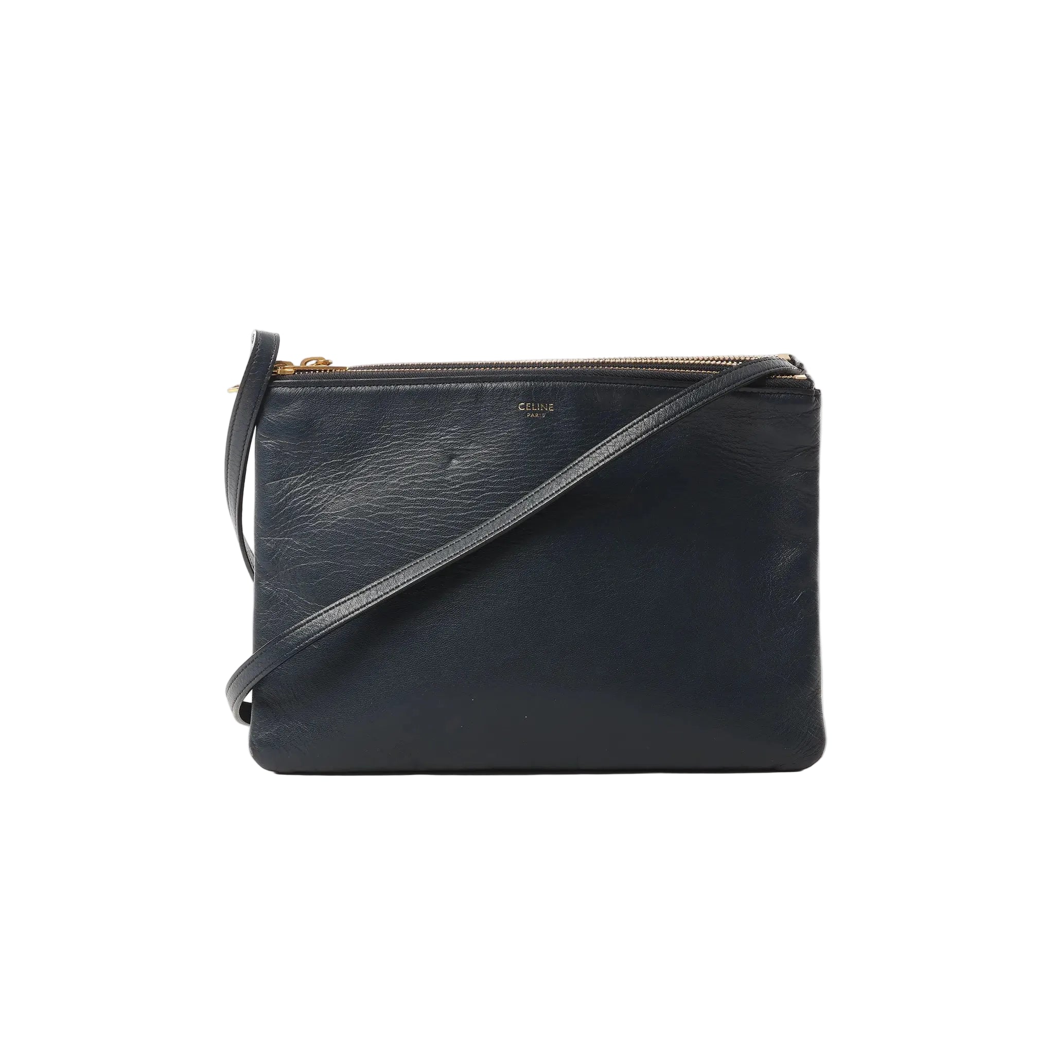 Black Celine Trio Large leather crossbody bag with gold-tone top zipper, slim strap, and small gold Celine Paris logo on front, on white background.