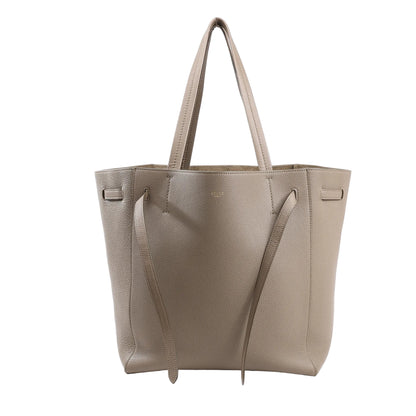 Celine Cabas Phantom Medium tote bag in taupe grained leather featuring a structured silhouette, long top handles, and decorative knotted side straps.