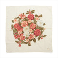 Beige Chanel silk handkerchief with a central bouquet of red, pink and white camellias, olive-green leaves and Chanel lettering in one corner.