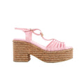 Side view of a pink Chanel patent leather sandal with slender straps, a gold-tone CC logo and buckle, and a ridged cork platform and block heel.