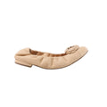 Side view of beige leather ballet flat with camellia flower applique on the toe and a low heel, photographed on a white background.