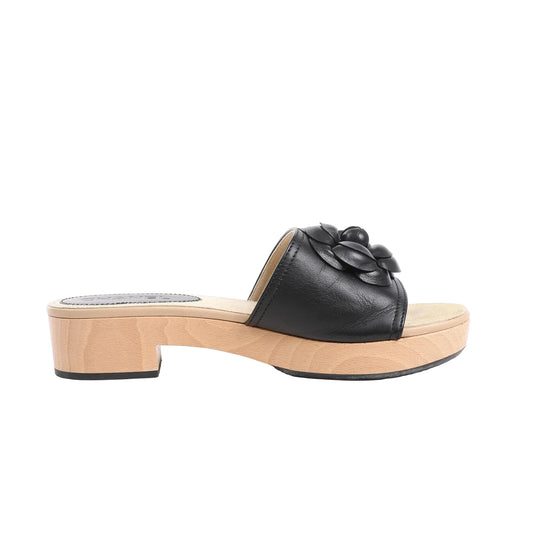 Chanel Camellia black leather mules in size 41 EU, featuring a natural wood sole with low chunky heel and a prominent black camellia flower embellishment on the upper, blending luxury with casual elegance.