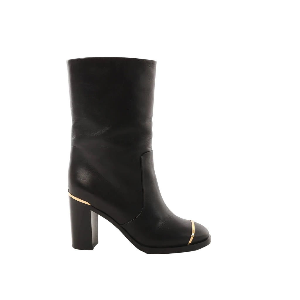 Chanel black leather mid-calf boot with block heel and gold trim accents at the toe and heel, shown in side profile on a white background.