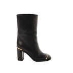 Chanel black leather mid-calf boot with block heel and gold trim accents at the toe and heel, shown in side profile on a white background.