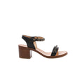 Side view of a Chanel sandal with black leather straps, gold-tone chain trim, an ankle buckle, tan footbed and brown block heel.