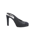 Side view of black Chanel slingback heel with glitter upper, rounded toe cap, platform sole, and high heel on white background.